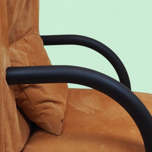 Detal zakrzywionego czarnego podłokietnika fotela Zen Ligne Roset, pomarańczowa tapicerka Alcantara