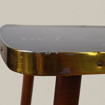 Zbliżenie na mosiężną krawędź stolika Alburette Busch, widoczna patyna i mocowanie przy szklanym blacie