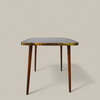 Stolik Alburette Busch, widok z boku na szklany blat z mosiężną listwą i drewniane nogi, German design