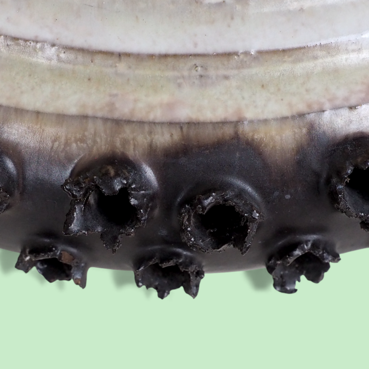 Zbliżenie dolnej krawędzi duńskiego klosza ceramicznego z brązowymi detalami