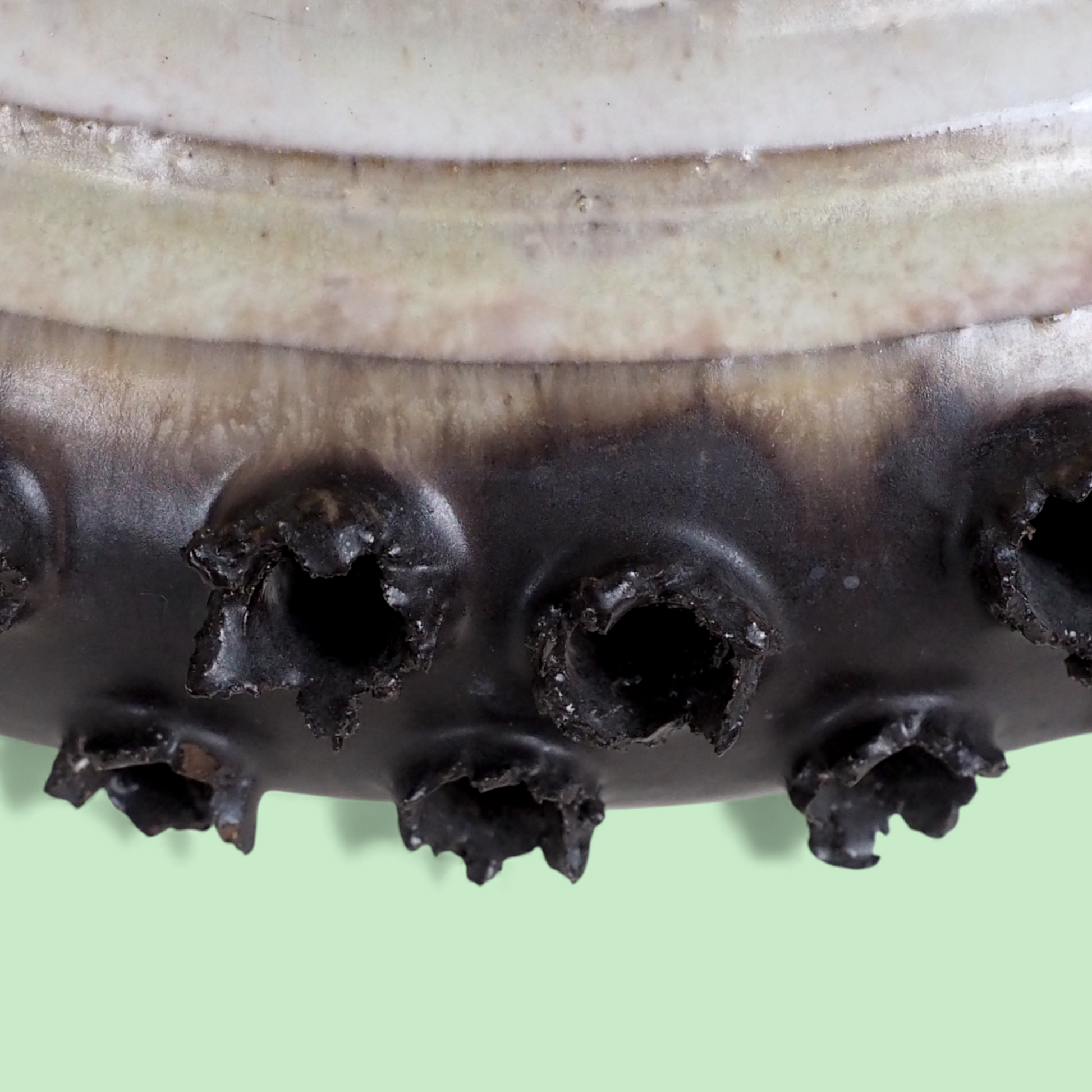Zbliżenie dolnej krawędzi duńskiego klosza ceramicznego z brązowymi detalami