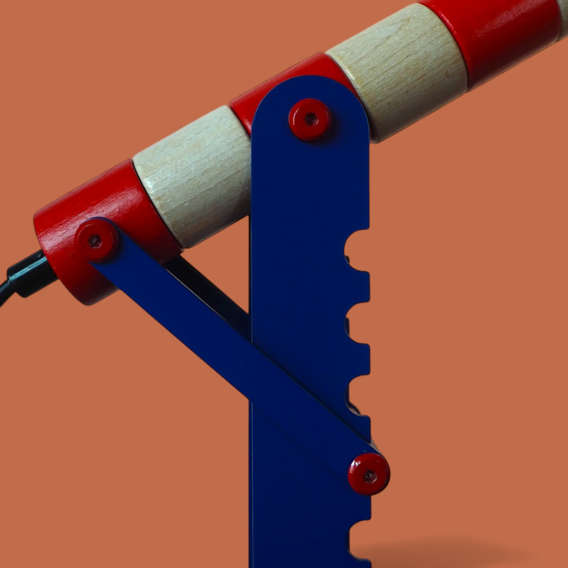 Detal mechanizmu zacisku lampki HABA Signal, niebieska metalowa podstawa i czerwone śruby