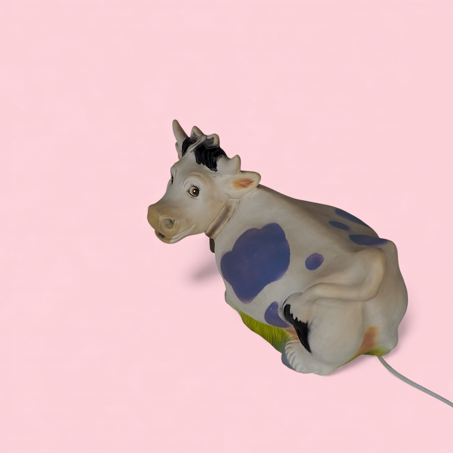 Lampka Heico krowa z lat 80., widok z z góry pod kątem, niebieskie łaty i trawa