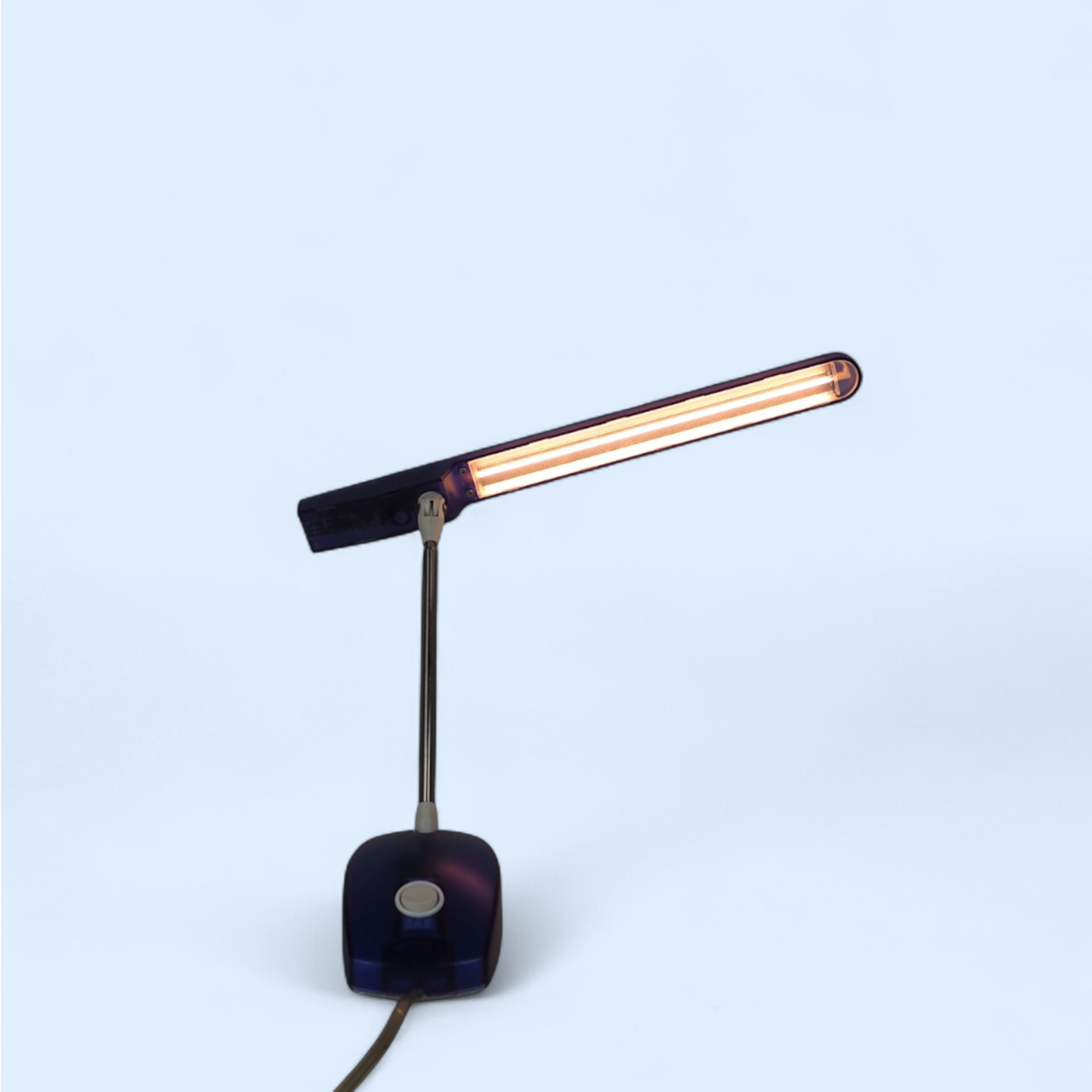 Lampka Microlight Artemide niebieska włączona pod kątem, widok ramienia i mechanizmu regulacji