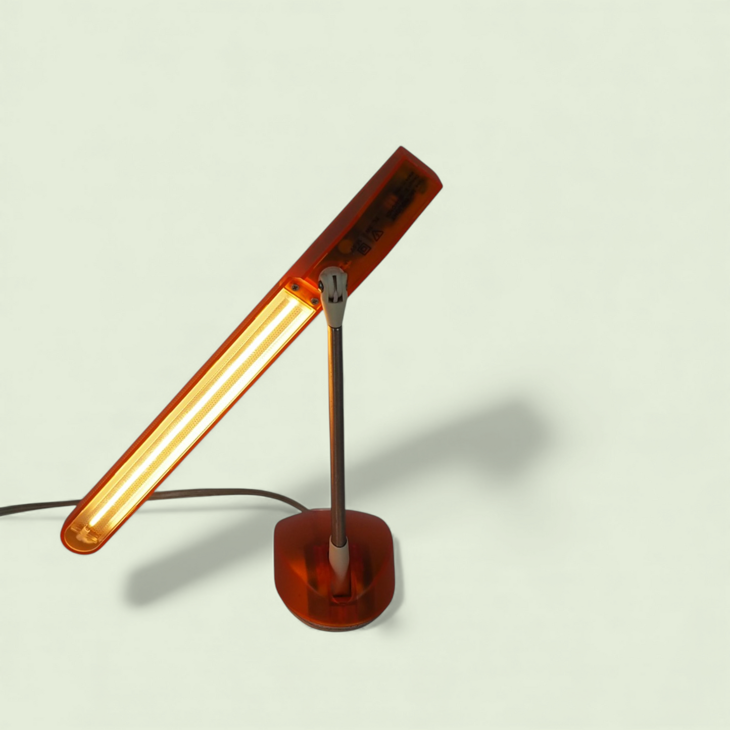 Desk lamp Microlight Artemide włączona pod kątem, bursztynowe świecenie, Italy